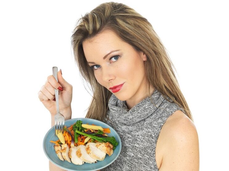 момиче, което яде пиле със зеленчуци за отслабване